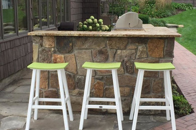 Example of a large arts and crafts backyard brick patio kitchen design in Other with no cover