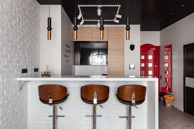 This is an example of a mid-sized industrial galley eat-in kitchen in Moscow with an undermount sink, flat-panel cabinets, medium wood cabinets, solid surface benchtops, white splashback, black appliances, ceramic floors, with island, grey floor and white benchtop.