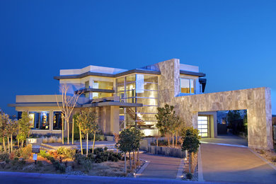 Photo of a large contemporary two-storey brown house exterior in Las Vegas with mixed siding and a flat roof.