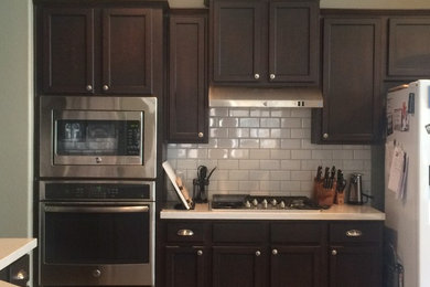 Foto de cocina moderna con armarios con paneles empotrados, puertas de armario de madera en tonos medios y salpicadero blanco
