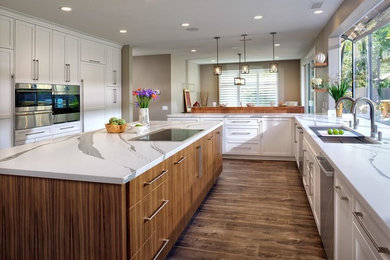 Inspiration for a large transitional l-shaped eat-in kitchen in Sacramento with an undermount sink, shaker cabinets, white cabinets, quartzite benchtops, panelled appliances, with island, brown floor, white benchtop and porcelain floors.
