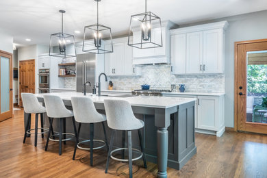 Large elegant single-wall medium tone wood floor open concept kitchen photo in Other with a single-bowl sink, recessed-panel cabinets, white cabinets, quartz countertops, blue backsplash, porcelain backsplash, stainless steel appliances, an island and yellow countertops