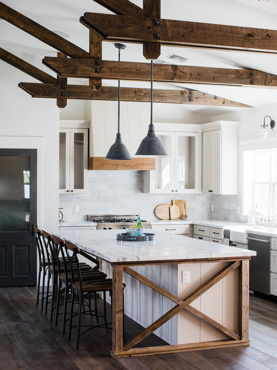 Farmhouse kitchen ideas - Example of a country l-shaped dark wood floor and brown floor kitchen design in Phoenix with a farmhouse sink, recessed-panel cabinets, white cabinets, gray backsplash, stainless steel appliances and an island