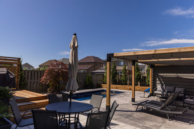 Pool - contemporary backyard rectangular pool idea in Toronto with decking