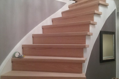 トロントにあるトラディショナルスタイルのおしゃれな階段 (フローリングの蹴込み板、木材の手すり) の写真