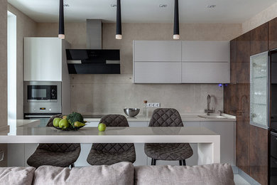 This is an example of a contemporary single-wall kitchen in Moscow with flat-panel cabinets, stainless steel appliances, grey cabinets, grey splashback, a peninsula and grey benchtop.