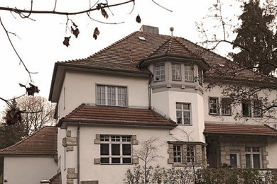 Großes Klassisches Einfamilienhaus mit Putzfassade, weißer Fassadenfarbe, Walmdach, Ziegeldach und rotem Dach in Berlin