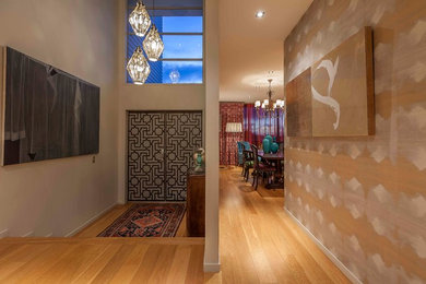 This is an example of a large asian foyer in Auckland with beige walls, light hardwood floors, a double front door and a metal front door.
