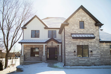 Example of a large transitional multicolored two-story board and batten exterior home design in Chicago with a black roof