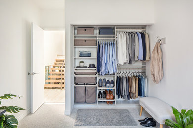 Small modern gender-neutral built-in wardrobe in New York with carpet, grey floor, open cabinets and white cabinets.