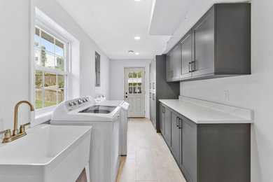 Galley ceramic tile and beige floor dedicated laundry room photo in DC Metro with quartz countertops, white walls, gray cabinets, window backsplash, a side-by-side washer/dryer and white countertops