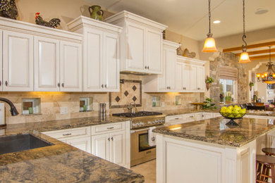 Inspiration for a galley ceramic tile open concept kitchen remodel in San Diego with a drop-in sink, beaded inset cabinets, white cabinets, beige backsplash, ceramic backsplash, stainless steel appliances and an island