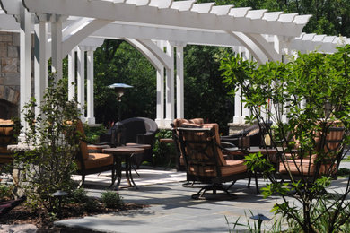 Design ideas for a traditional drought-tolerant backyard stone landscaping in Chicago with a fireplace.
