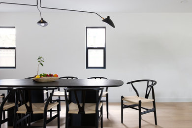Ispirazione per una piccola sala da pranzo aperta verso il soggiorno minimalista con parquet chiaro e pavimento bianco