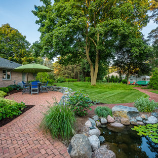 Großer Stilmix Garten hinter dem Haus mit Teich, direkter Sonneneinstrahlung und Pflasterklinker in Milwaukee