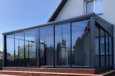 Inspiration for a mid-sized contemporary sunroom remodel in Other with a glass ceiling