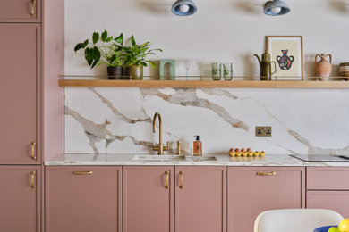 Photo of a contemporary single-wall kitchen/diner in Other with a submerged sink, shaker cabinets, pink cabinets, white splashback, stone slab splashback, integrated appliances, medium hardwood flooring, no island, brown floors and white worktops.