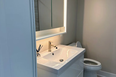 Example of a trendy single-sink bathroom design in DC Metro with flat-panel cabinets, white cabinets, quartzite countertops, white countertops and a floating vanity