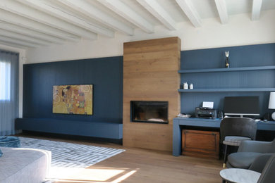 Ispirazione per un soggiorno design con pareti blu, pavimento in legno verniciato, camino classico, cornice del camino in legno, boiserie e con abbinamento di mobili antichi e moderni