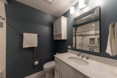 На фото: главная ванная комната среднего размера в стиле неоклассика (современная классика) с фасадами в стиле шейкер, белыми фасадами, ванной в нише, душем в нише, унитазом-моноблоком, красной плиткой, плиткой кабанчик, синими стенами, полом из керамогранита, врезной раковиной, столешницей из искусственного кварца, серым полом, шторкой для ванной, белой столешницей, нишей, тумбой под одну раковину и встроенной тумбой с