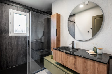 Idées déco pour une salle d'eau moderne de taille moyenne avec des portes de placards vertess, une douche à l'italienne, un carrelage beige, des carreaux de céramique, un mur gris, un sol en carrelage de céramique, un plan vasque, un plan de toilette en verre, un sol beige, une cabine de douche à porte coulissante, un plan de toilette noir, une fenêtre, meuble simple vasque et meuble-lavabo suspendu.