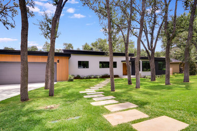 Example of a mid-sized 1960s multicolored one-story mixed siding and board and batten exterior home design in Austin with a black roof