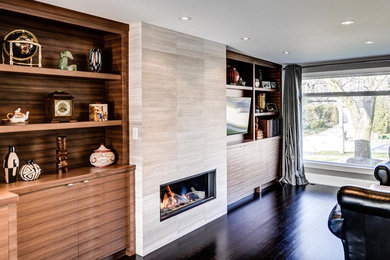 This is an example of a contemporary family room in Toronto with a tile fireplace surround.