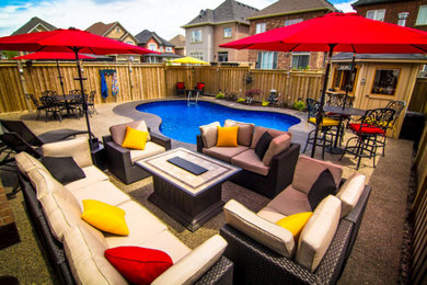 Mid-sized transitional backyard stamped concrete pool photo in Toronto