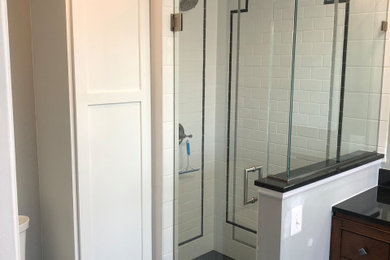 Inspiration for a large 1960s master white tile and cement tile porcelain tile, black floor and single-sink bathroom remodel in Baltimore with dark wood cabinets, a two-piece toilet, gray walls, an integrated sink, granite countertops, a hinged shower door, black countertops, a niche, a built-in vanity and shaker cabinets