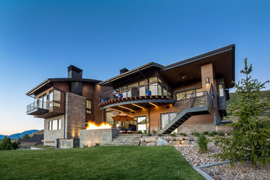 Example of a mid-sized trendy brown three-story wood house exterior design in Salt Lake City with a hip roof and a metal roof