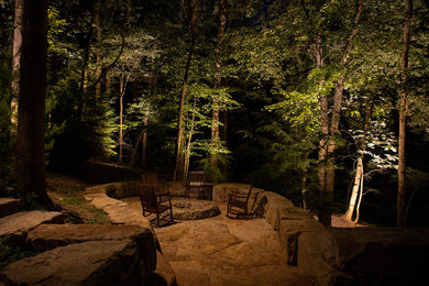 Example of a mountain style backyard patio design in Other with a fire pit and no cover