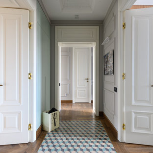 Klassisk inredning av en mellanstor hall, med vita väggar, mellanmörkt trägolv och brunt golv