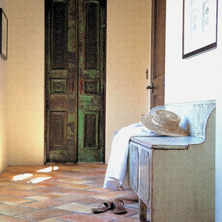 Foto på en vintage hall, med vita väggar och klinkergolv i terrakotta