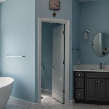 Traditional master bath utilizing frosted and clear glass to allow for needed pr
