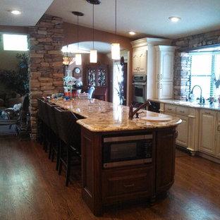 Large transitional kitchen pantry ideas - Kitchen pantry - large transitional galley dark wood floor kitchen pantry idea in Wichita with an undermount sink, raised-panel cabinets, dark wood cabinets, granite countertops, multicolored backsplash, stone slab backsplash, stainless steel appliances and an island