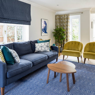 Medium sized contemporary formal enclosed living room in Surrey with grey walls, light hardwood flooring, a wall mounted tv and beige floors.