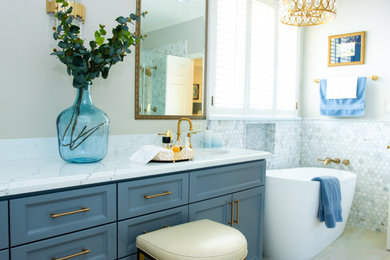 Modelo de cuarto de baño tradicional renovado con bañera exenta, baldosas y/o azulejos blancos, baldosas y/o azulejos de mármol, suelo de baldosas de porcelana y paredes grises