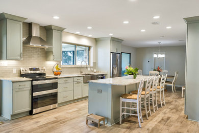 Eat-in kitchen - mid-sized transitional galley cork floor and brown floor eat-in kitchen idea in Other with a farmhouse sink, shaker cabinets, blue cabinets, granite countertops, white backsplash, glass sheet backsplash, stainless steel appliances and an island