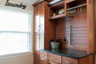 Dedicated laundry room - mid-sized traditional u-shaped medium tone wood floor dedicated laundry room idea in Kansas City with an undermount sink, shaker cabinets, medium tone wood cabinets, granite countertops, beige walls and a side-by-side washer/dryer