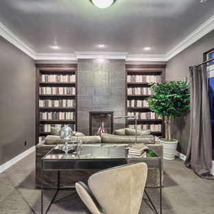 Modern home office and library in Denver with grey walls, carpet, a standard fireplace, a tiled fireplace surround, a freestanding desk and beige floors.