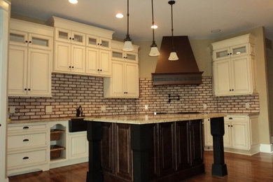 Eat-in kitchen - mid-sized traditional l-shaped medium tone wood floor eat-in kitchen idea in Columbus with raised-panel cabinets, white cabinets, granite countertops and an island