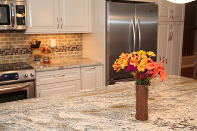 Kitchen - mid-sized l-shaped medium tone wood floor kitchen idea in DC Metro with a farmhouse sink, raised-panel cabinets, granite countertops, stainless steel appliances and an island