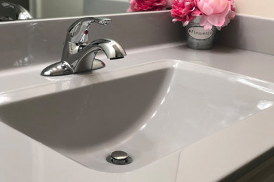 Example of a mid-sized minimalist kids' bathroom design in Kansas City with white cabinets, white walls, marble countertops and gray countertops