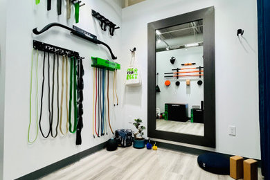 Example of a mid-sized urban gray floor and exposed beam home yoga studio design in Houston with white walls