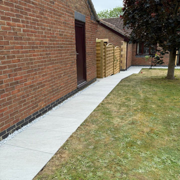 Porcelain Path Along a Brick Wall With a Shingle Strip