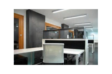 Ejemplo de despacho actual de tamaño medio con paredes blancas, suelo vinílico, escritorio independiente y suelo negro