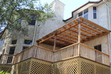 Example of a large mountain style backyard wood railing deck design in Austin with a pergola