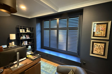 Home office library - traditional freestanding desk light wood floor home office library idea in Detroit with blue walls