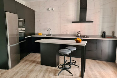Diseño de cocinas en L gris y negra minimalista abierta con fregadero de un seno, electrodomésticos de acero inoxidable y una isla