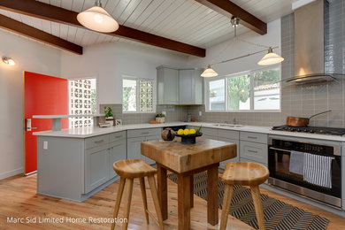 Example of a minimalist kitchen design in Los Angeles with shaker cabinets, gray cabinets and stainless steel appliances